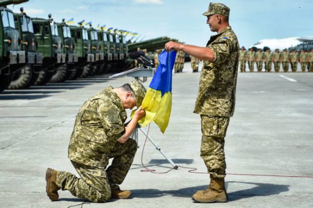 Порошенко целует государственный флаг Украины.